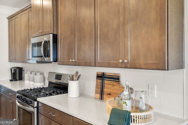 kitchen with appliances with stainless steel finishes, backsplash, and light stone counters