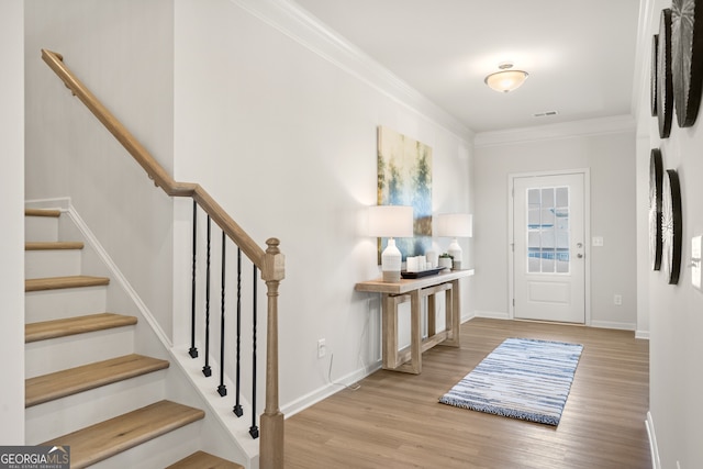 entrance foyer with crown molding and light hardwood / wood-style flooring