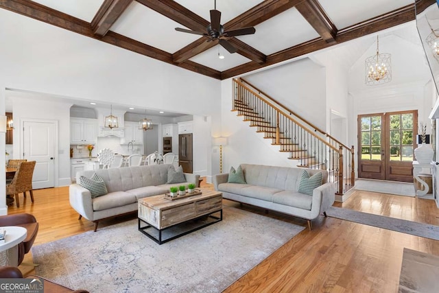 living room featuring a high ceiling, coffered ceiling, and light hardwood / wood-style flooring