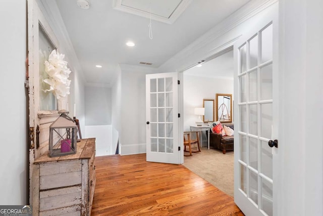 corridor with french doors, crown molding, and hardwood / wood-style floors