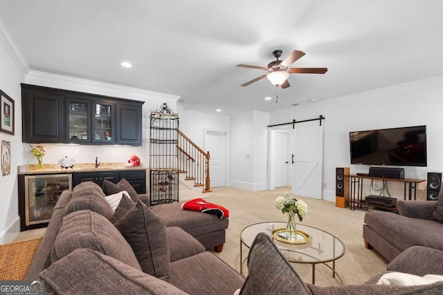 living room with indoor wet bar, wine cooler, light colored carpet, crown molding, and a barn door