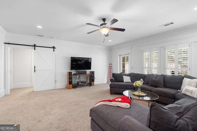 living room featuring light colored carpet, ornamental molding, a barn door, and ceiling fan