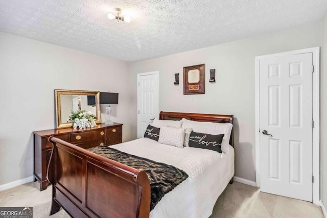 bedroom with light carpet and a textured ceiling