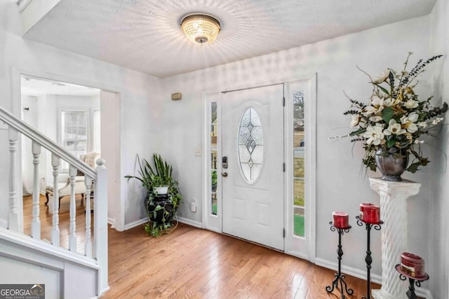 entryway with light hardwood / wood-style floors and a textured ceiling