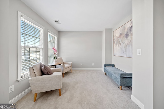 sitting room featuring carpet floors, visible vents, and baseboards