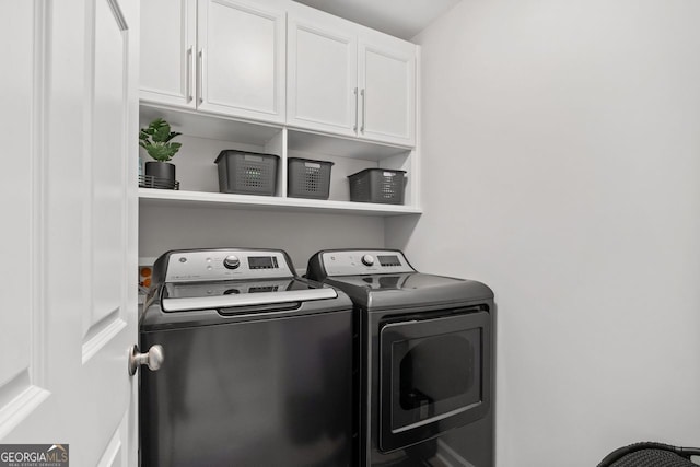 washroom with cabinet space and washing machine and clothes dryer