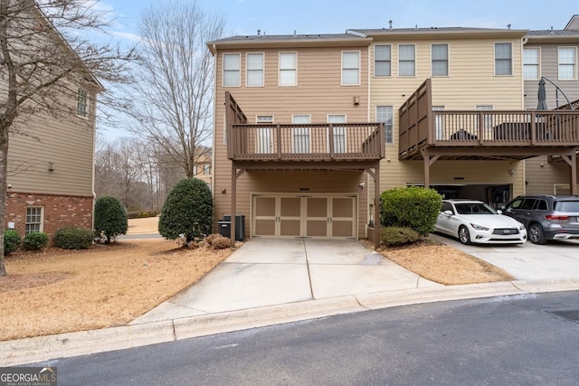 townhome / multi-family property with an attached garage, central AC unit, and concrete driveway