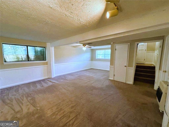 bonus room with ceiling fan, carpet floors, heating unit, and a textured ceiling