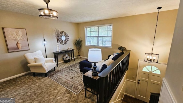 living area featuring dark carpet, a textured ceiling, and a notable chandelier