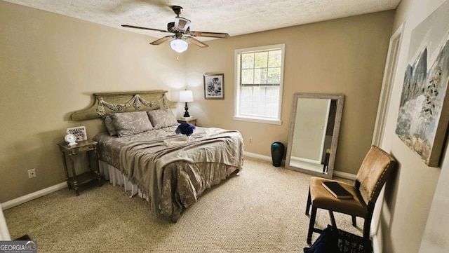 bedroom featuring ceiling fan, carpet floors, and a textured ceiling