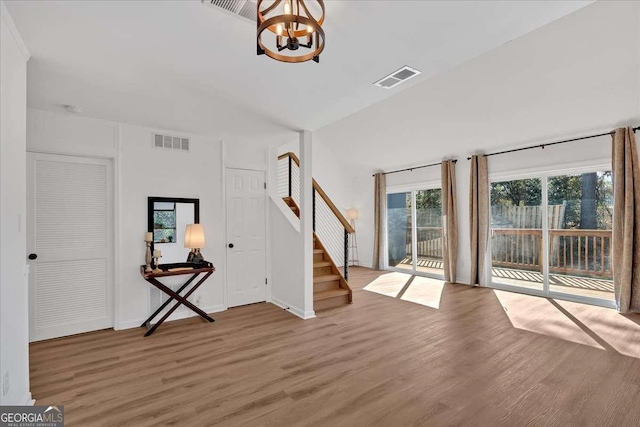 unfurnished living room featuring wood-type flooring and a chandelier