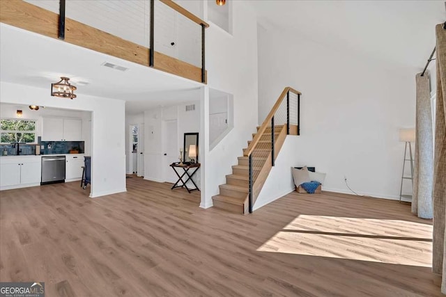 foyer featuring a towering ceiling and light hardwood / wood-style flooring