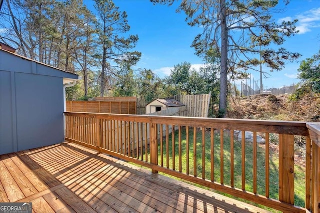 wooden deck featuring a shed and a lawn