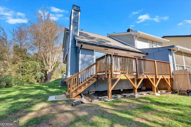 rear view of property featuring a wooden deck, central AC unit, and a lawn