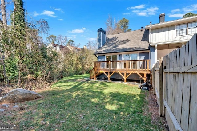 rear view of property with a yard and a deck