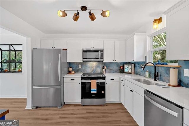 kitchen featuring white cabinetry, appliances with stainless steel finishes, sink, and backsplash