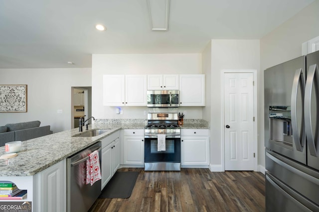 kitchen featuring sink, light stone counters, appliances with stainless steel finishes, kitchen peninsula, and white cabinets