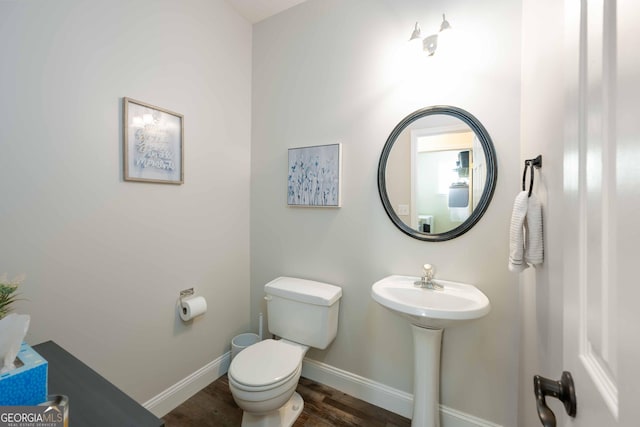 bathroom with hardwood / wood-style flooring, sink, and toilet