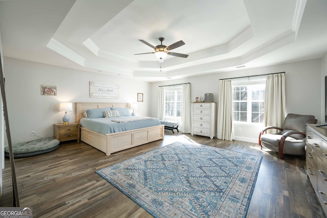 bedroom featuring dark hardwood / wood-style flooring, a raised ceiling, and multiple windows