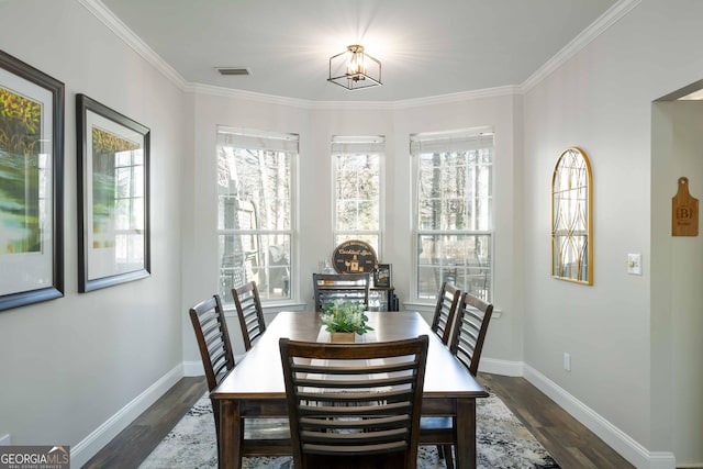 dining room featuring an inviting chandelier, a wealth of natural light, ornamental molding, and dark hardwood / wood-style floors