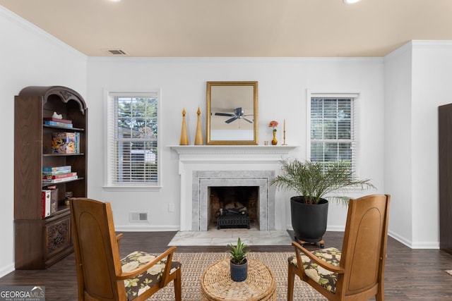 sitting room with ornamental molding, a fireplace, and dark hardwood / wood-style flooring