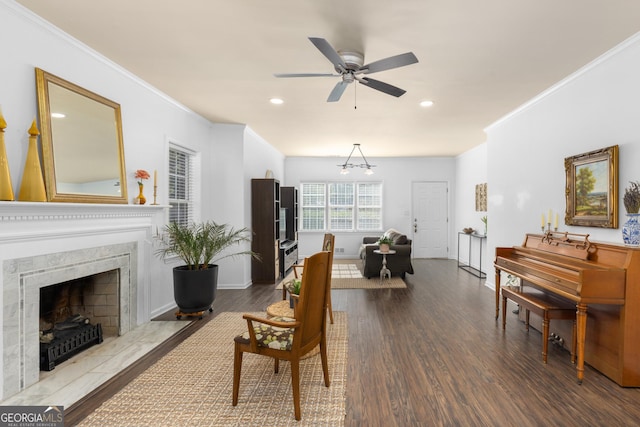 living room with hardwood / wood-style flooring, a premium fireplace, ceiling fan, and crown molding