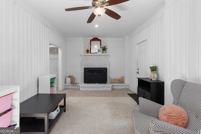 living room featuring ceiling fan and a fireplace