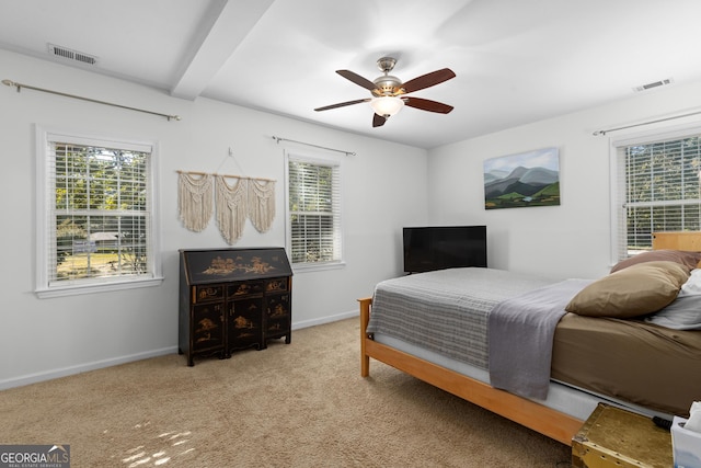 bedroom featuring beamed ceiling, light colored carpet, and ceiling fan