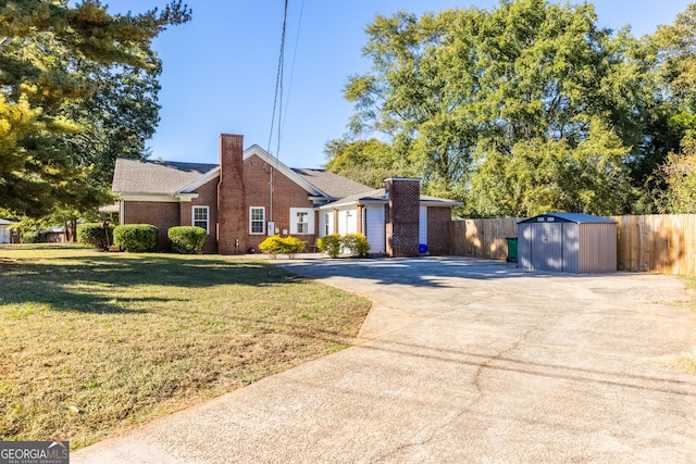 view of front of home featuring a front yard and a storage unit