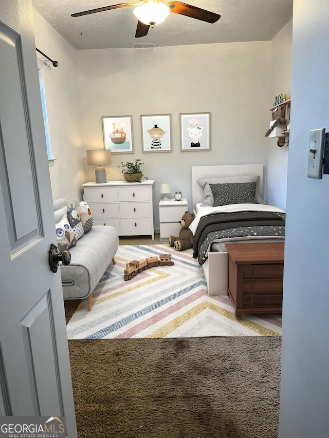 bedroom featuring ceiling fan and carpet