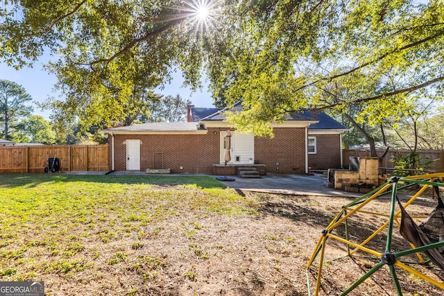 back of property with a patio area and a lawn