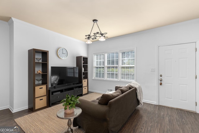 living room with ornamental molding, dark hardwood / wood-style flooring, and a notable chandelier