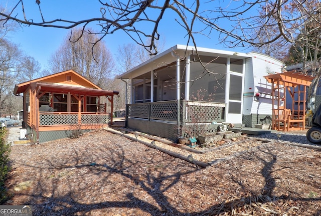 view of property exterior featuring a sunroom and covered porch