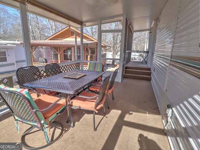 sunroom / solarium with a ceiling fan