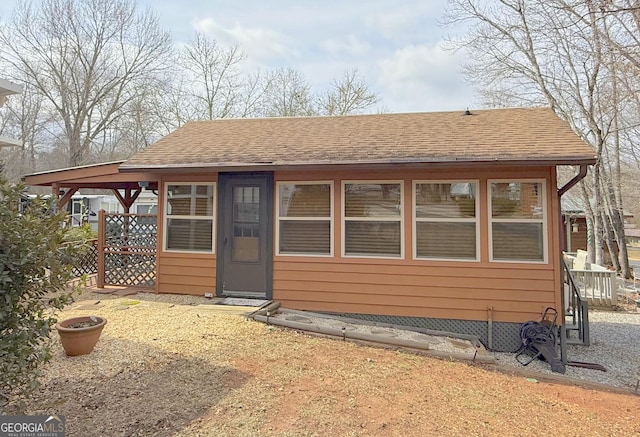 exterior space with roof with shingles