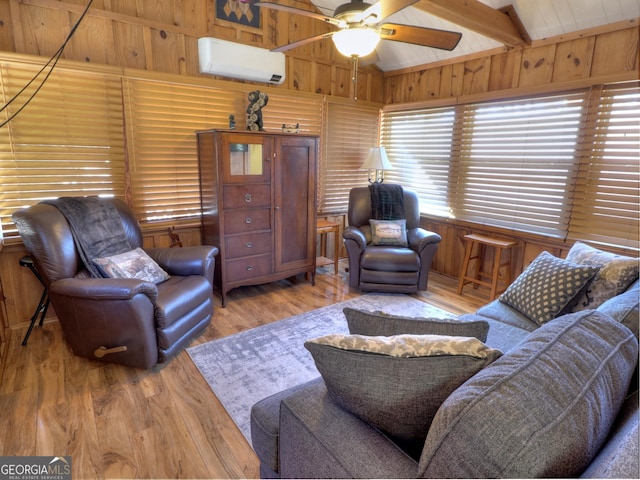 living area featuring wooden walls, a ceiling fan, a wall unit AC, lofted ceiling with beams, and wood finished floors