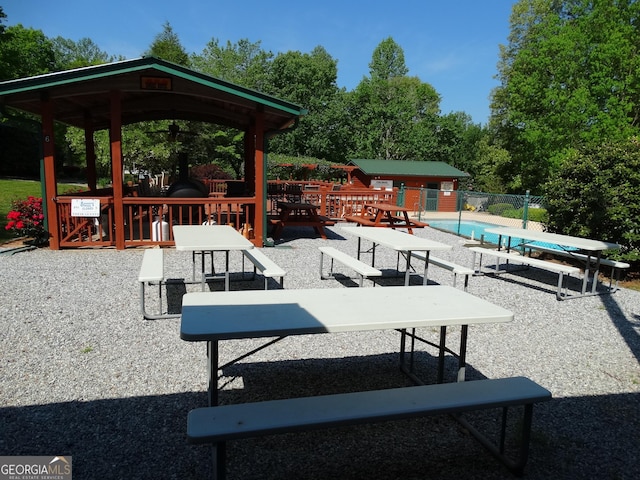 view of property's community featuring a pool, an outbuilding, and fence