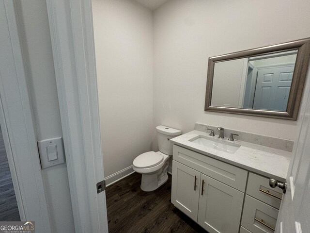 bathroom featuring hardwood / wood-style flooring, vanity, and toilet