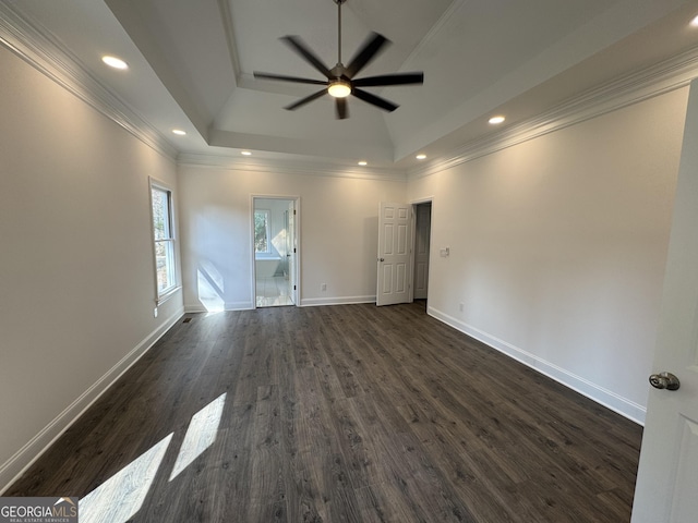 unfurnished room featuring crown molding, dark wood-type flooring, a raised ceiling, and ceiling fan