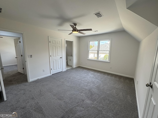 unfurnished bedroom featuring lofted ceiling, dark carpet, and ceiling fan