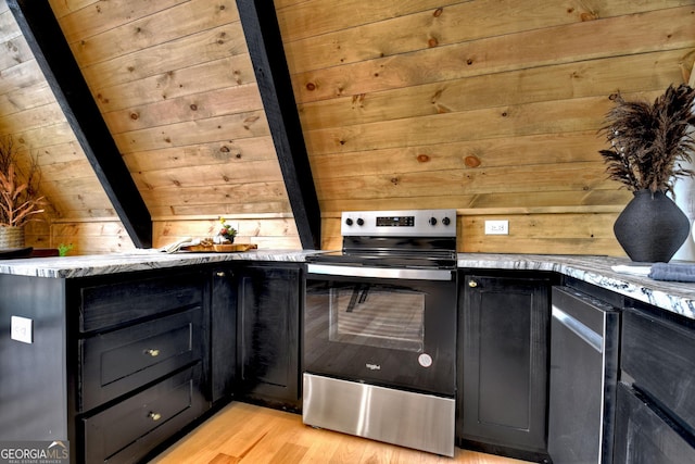 kitchen featuring light wood-style flooring, dark cabinetry, wooden walls, stainless steel electric range oven, and vaulted ceiling with beams