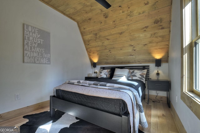 bedroom featuring lofted ceiling, wood ceiling, wood finished floors, and baseboards