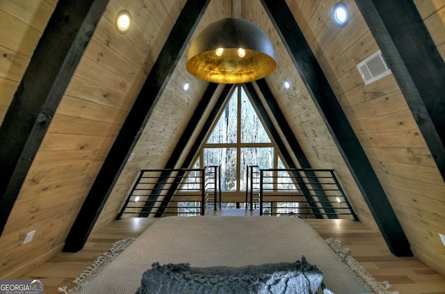 bedroom featuring visible vents, wood walls, wooden ceiling, and wood finished floors