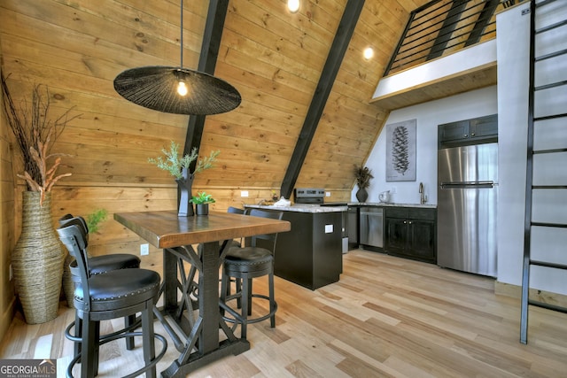 dining room with light wood-style flooring, vaulted ceiling with beams, wood ceiling, and wood walls