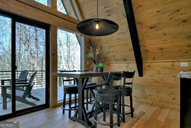 dining space featuring wooden walls and light wood finished floors