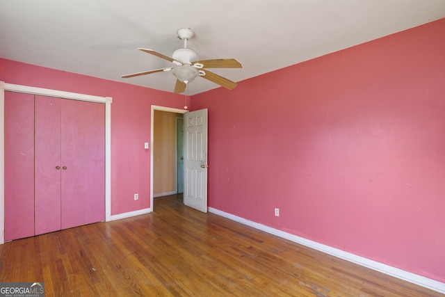 unfurnished bedroom featuring hardwood / wood-style flooring, ceiling fan, and a closet