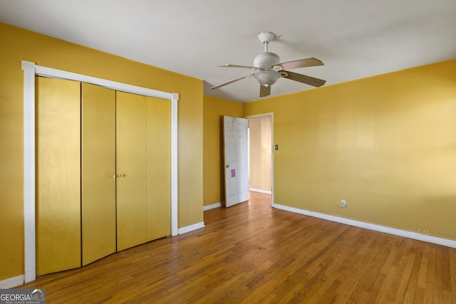 unfurnished bedroom with hardwood / wood-style flooring, ceiling fan, and a closet