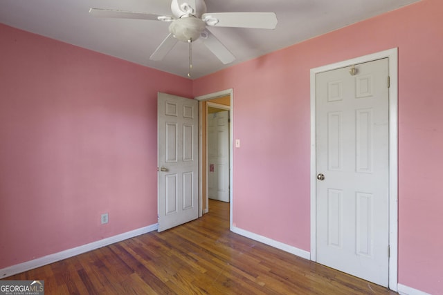 unfurnished bedroom with ceiling fan and dark hardwood / wood-style flooring