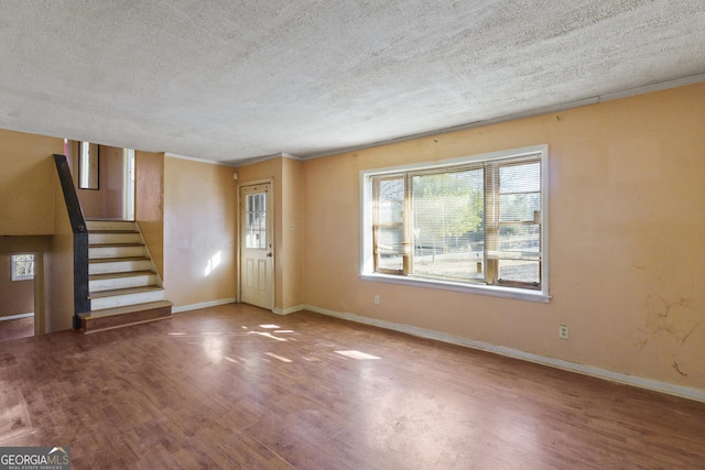 entrance foyer featuring hardwood / wood-style flooring, crown molding, and a textured ceiling