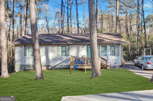 ranch-style house featuring a front lawn and a deck